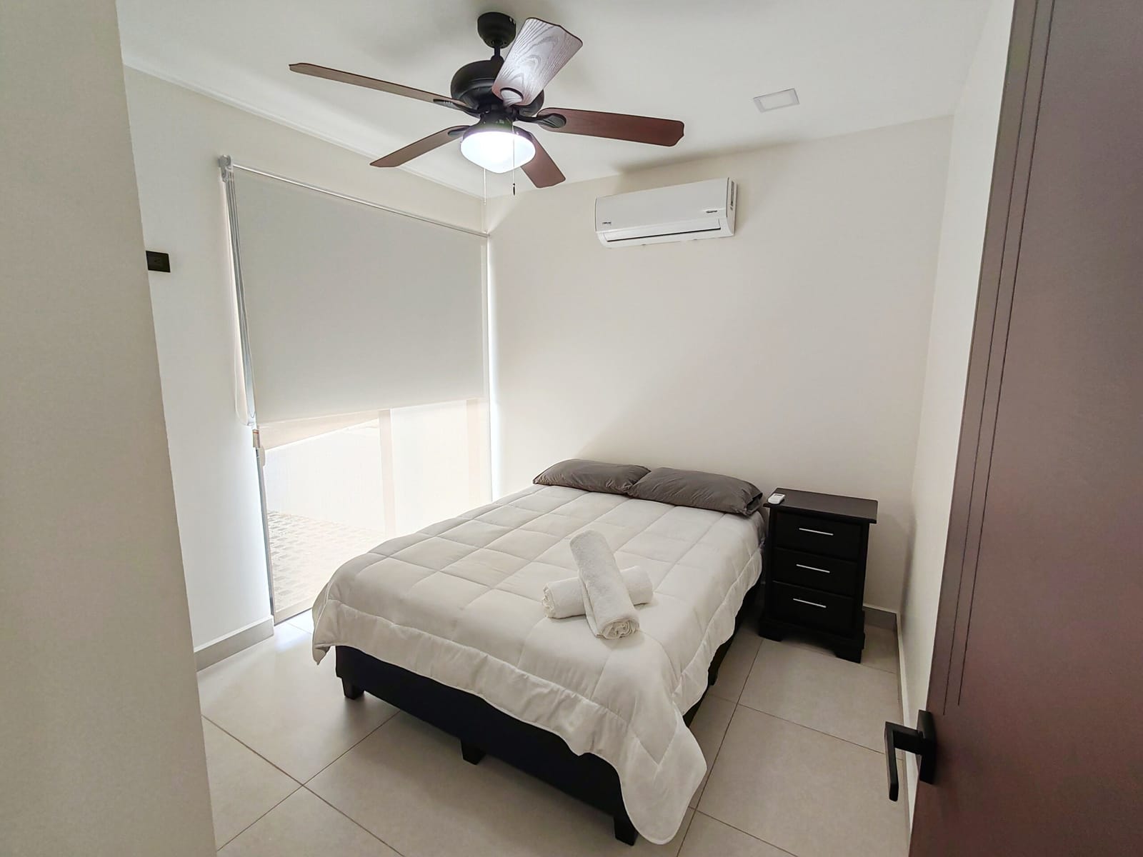Bedroom with double bed, ceiling fan and AC unit