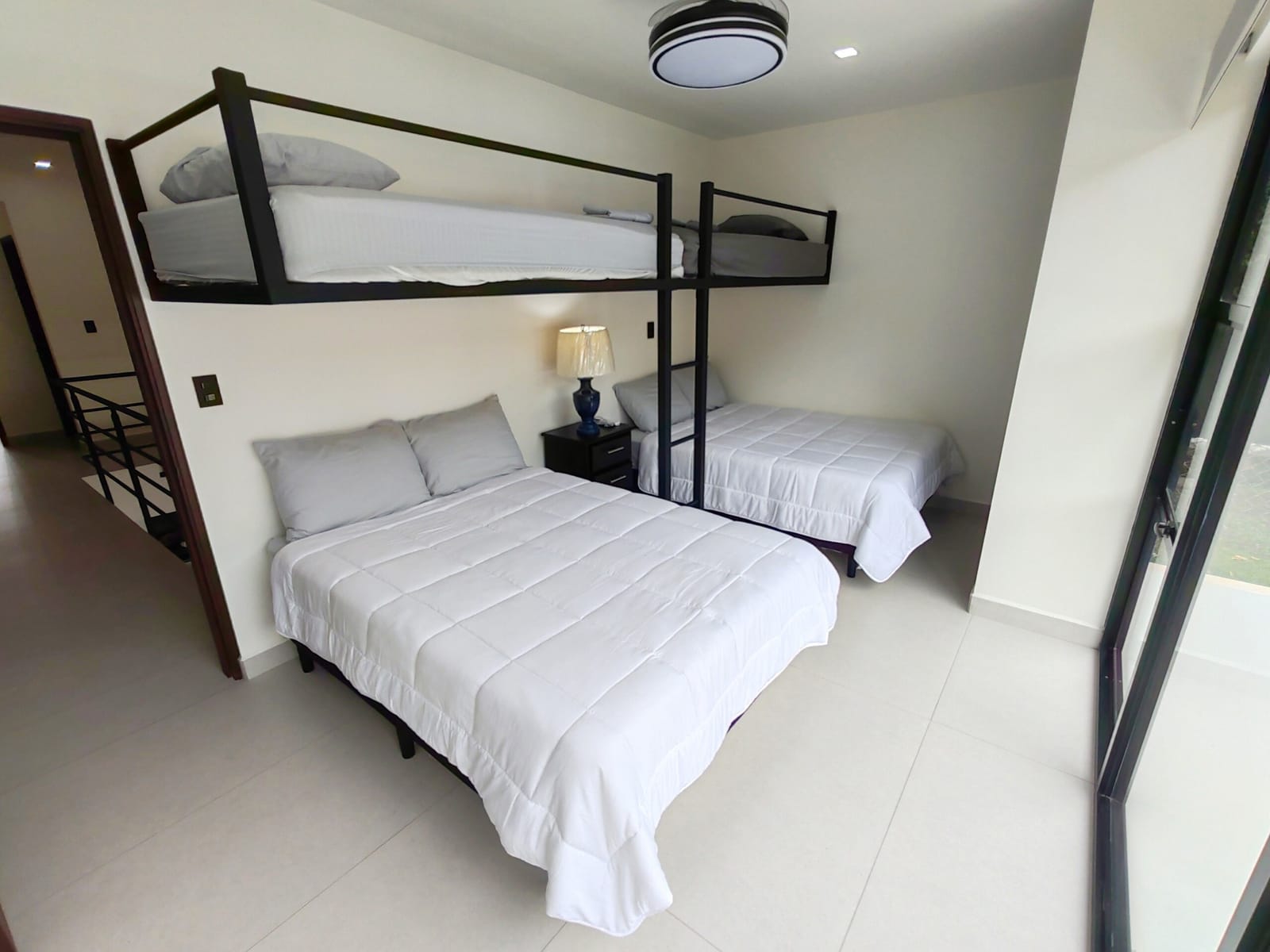 Bedroom with bunk above and lamp on the nightstand