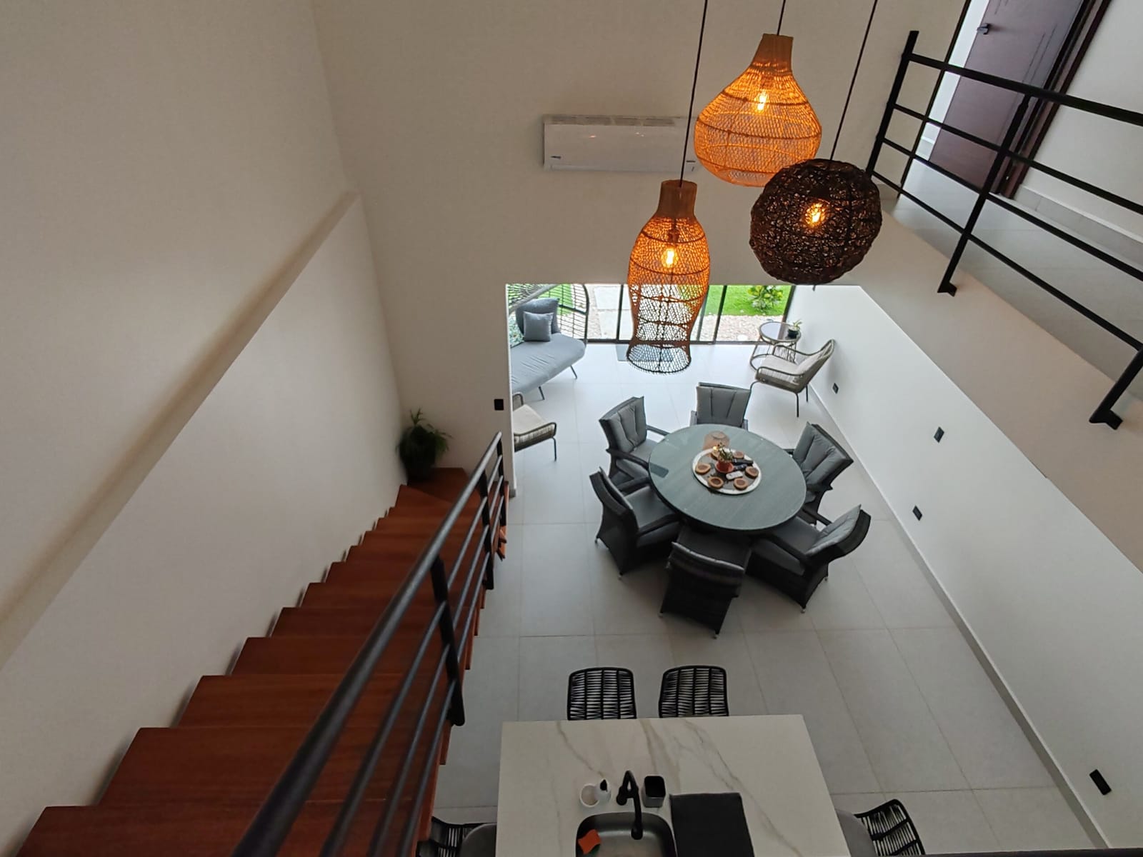 Rattan pendant lamps over the dining table from the stair