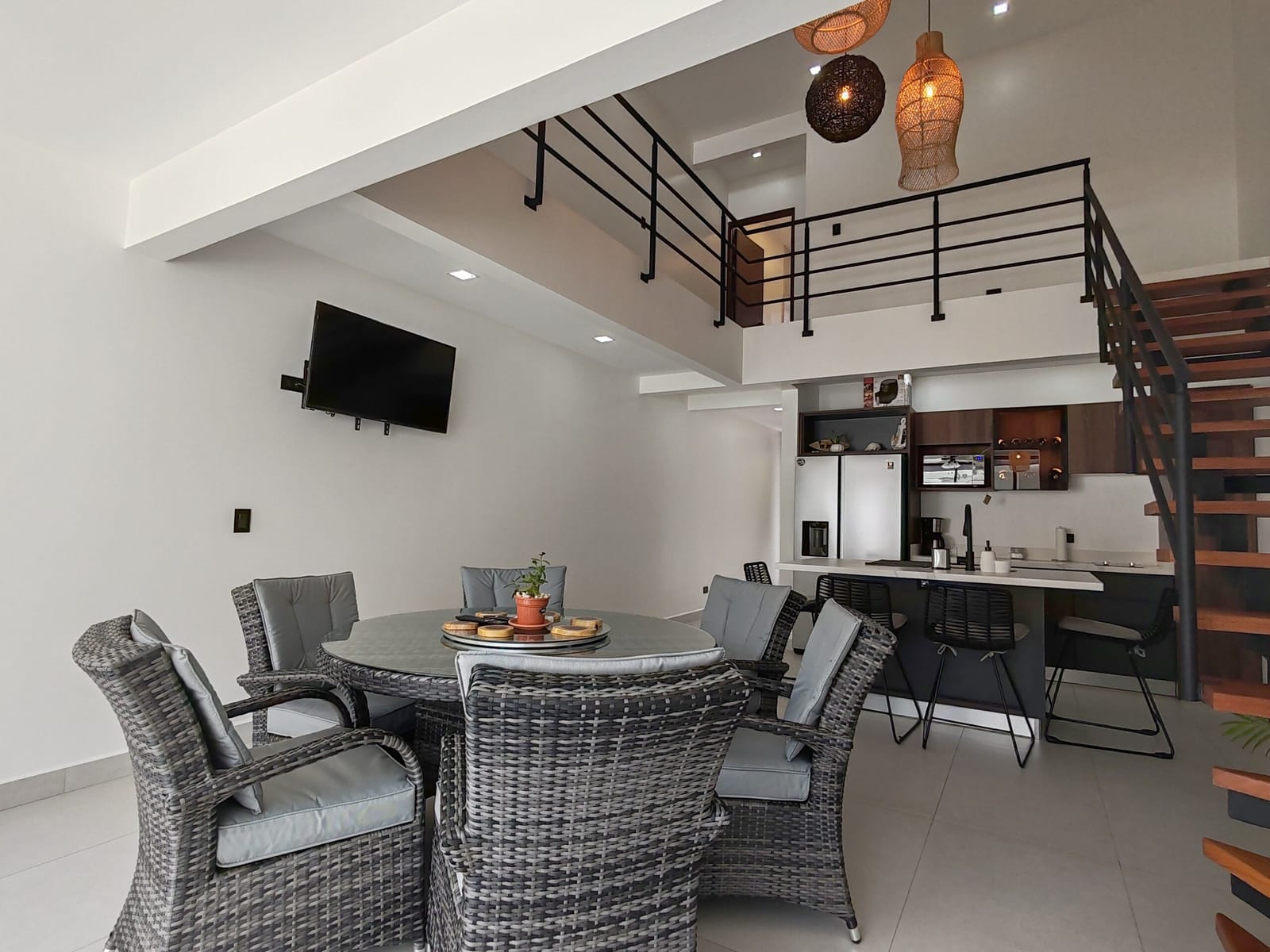 Dining area with rattan chairs under the mezzanine