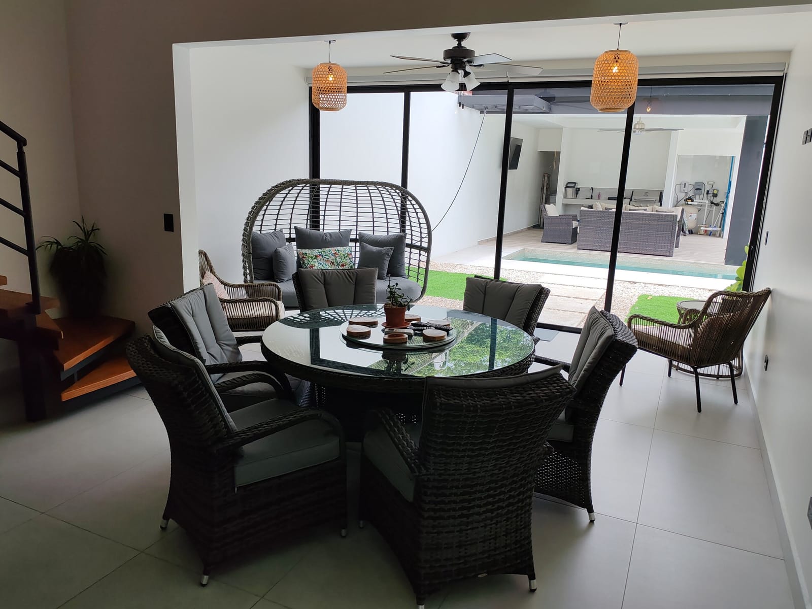 Hanging egg chair and dining set by the glass doors