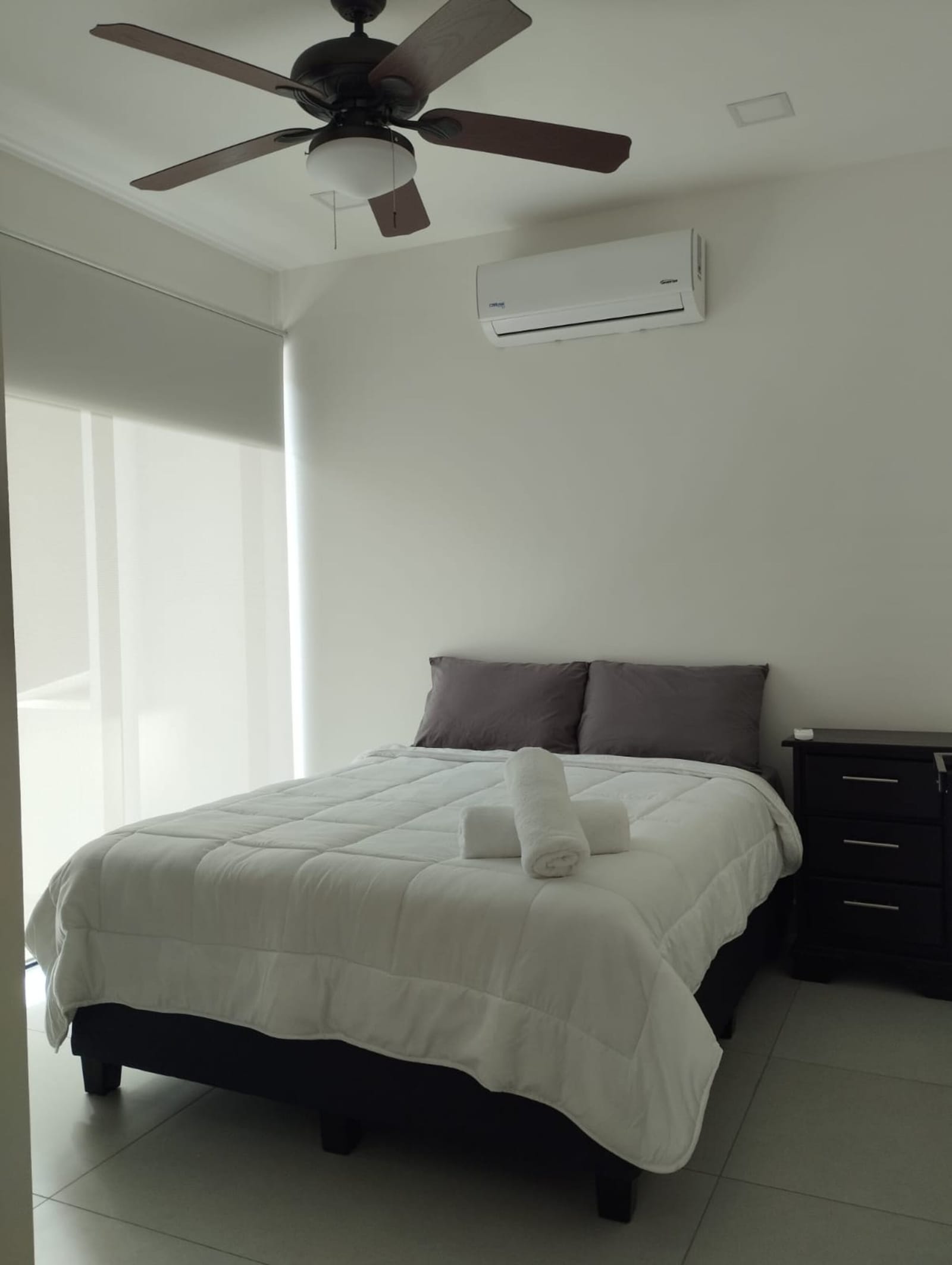 Bedroom with double bed, ceiling fan and AC unit