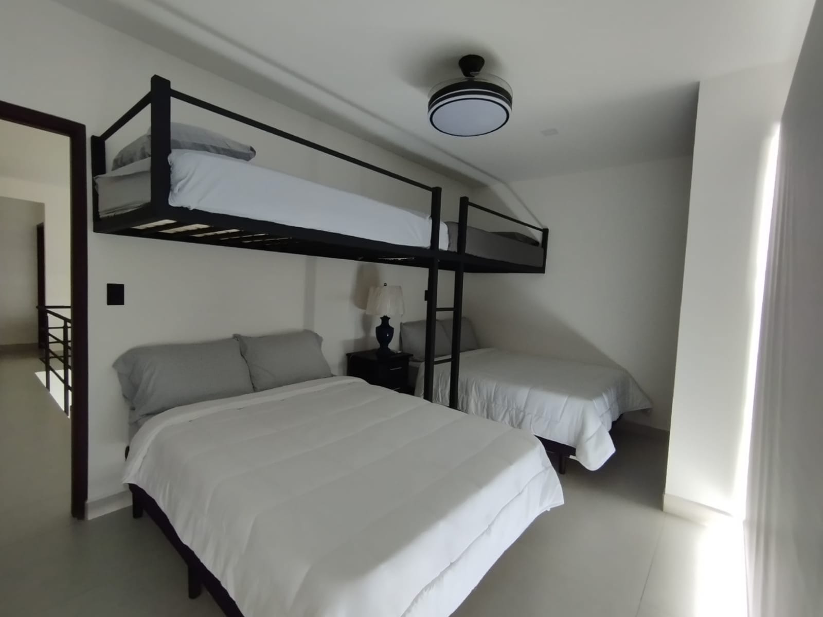 Bunk beds over two double beds with a ceiling fan