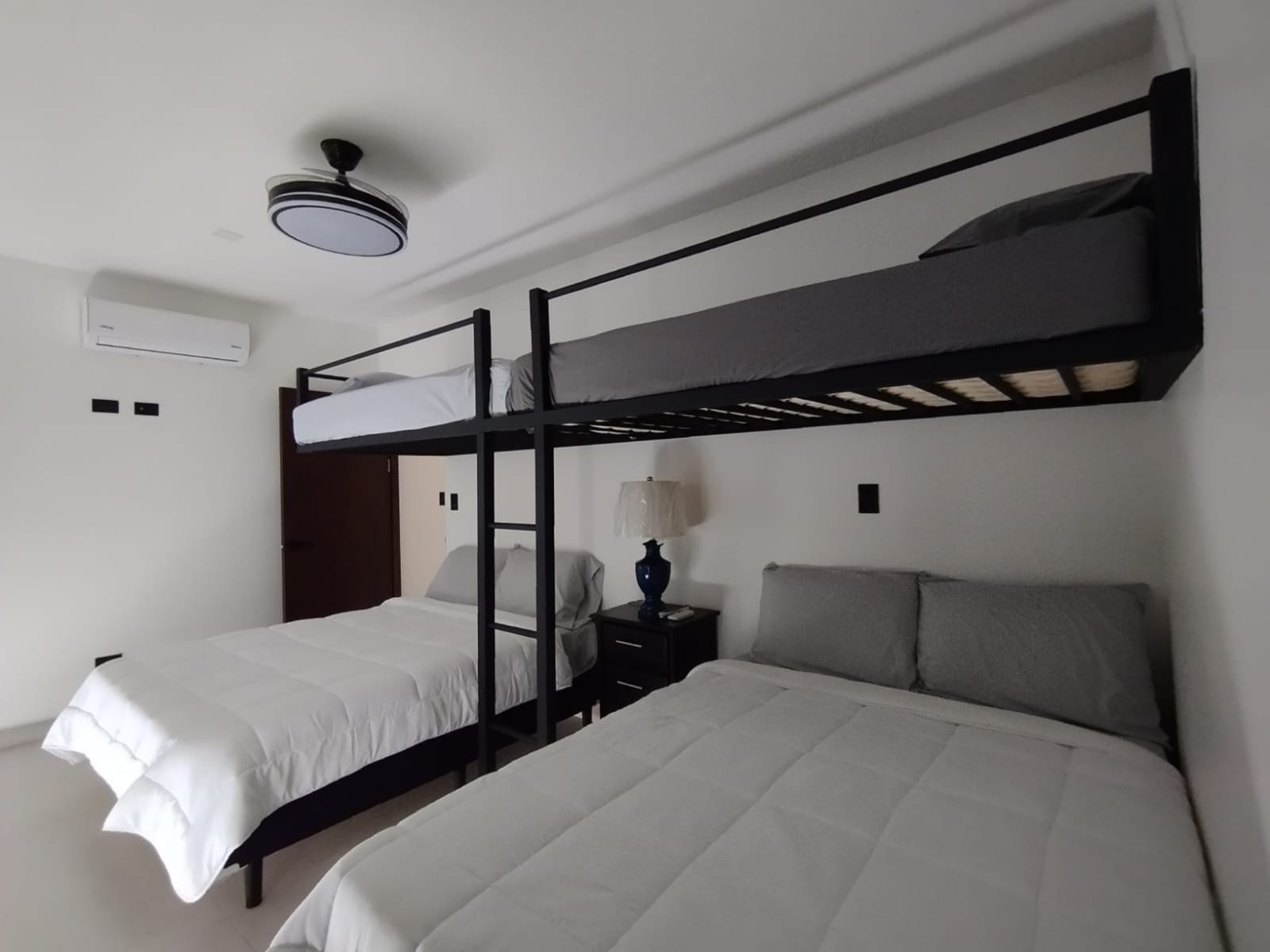 Loft bunk above a double bed with AC unit
