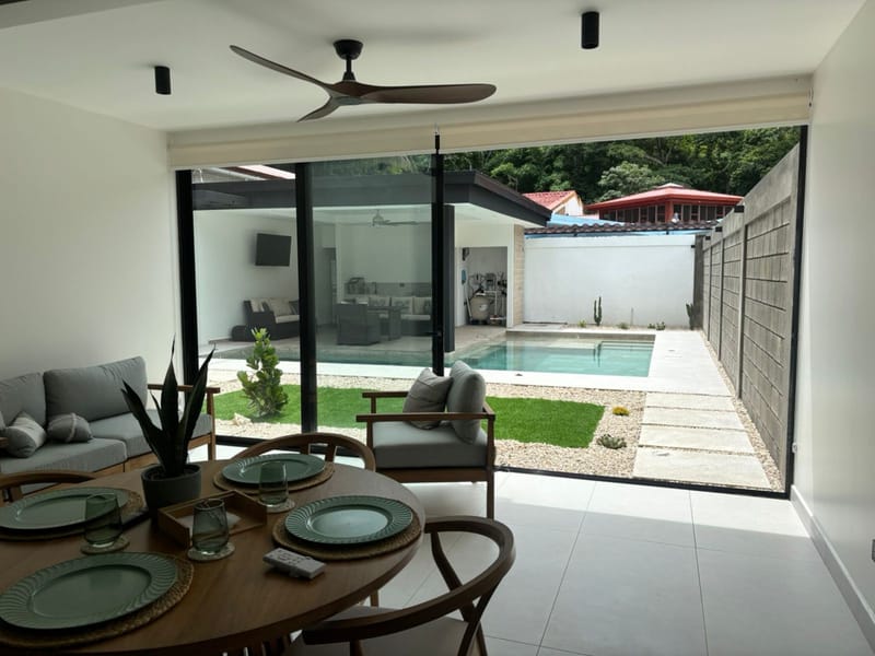 Round dining table by the open glass doors to the pool