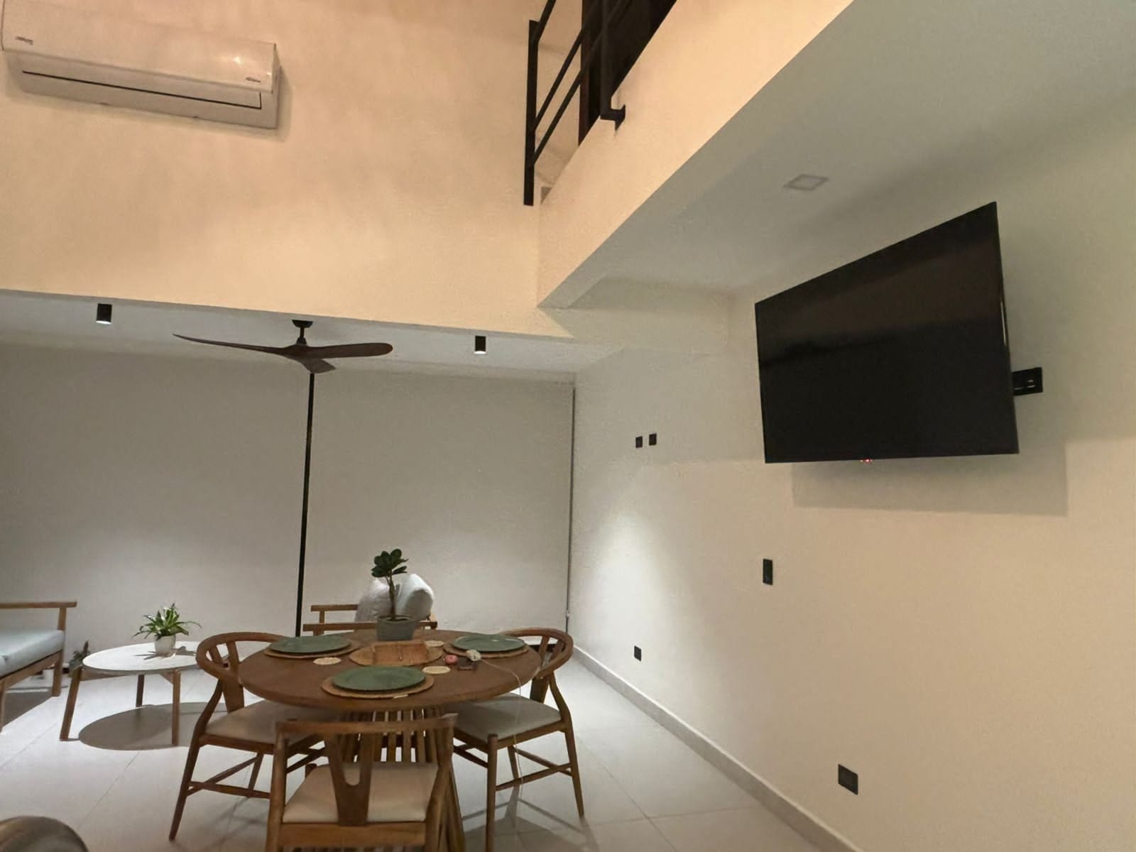 Dining table under the mezzanine with ceiling fan and TV