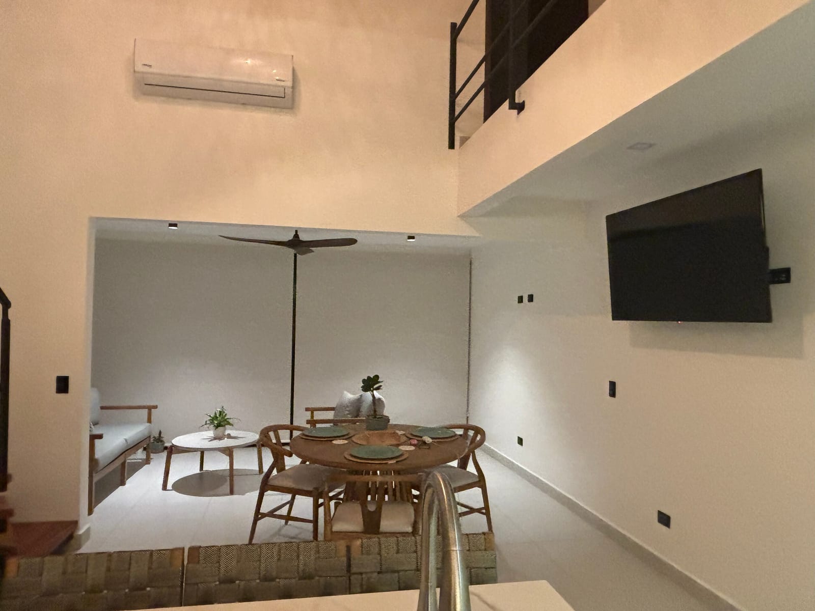 Wall-mounted TV over the dining table with AC unit