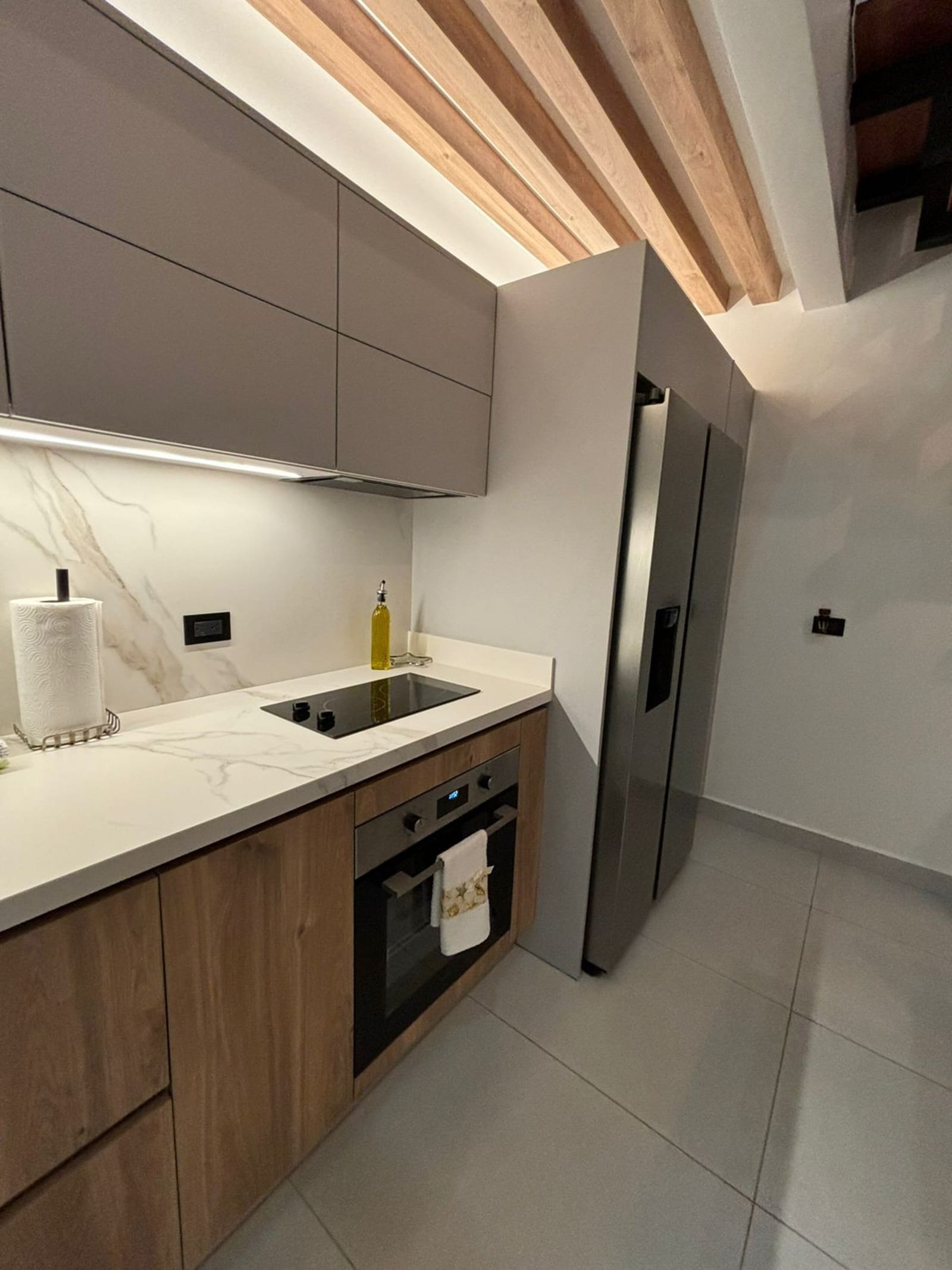 White kitchen cabinets with induction cooktop and built-in oven
