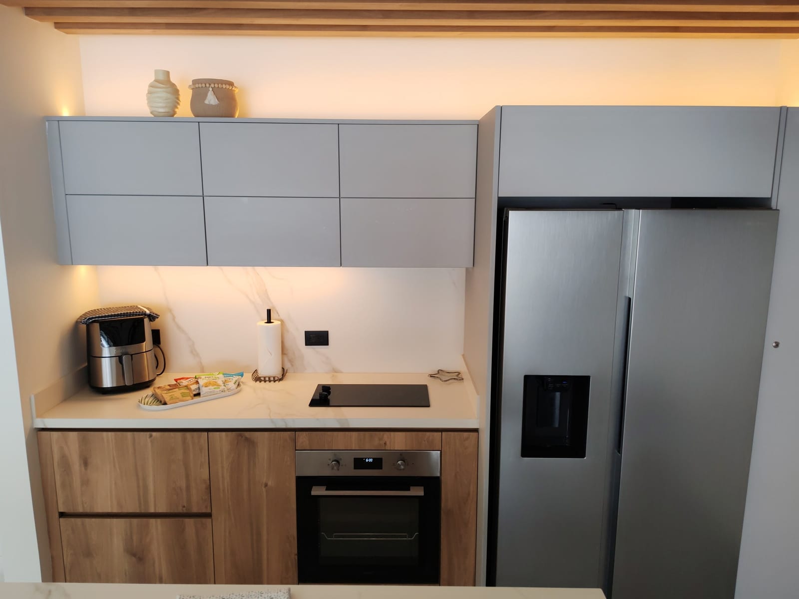 Kitchen with air fryer, cooktop and water dispenser fridge