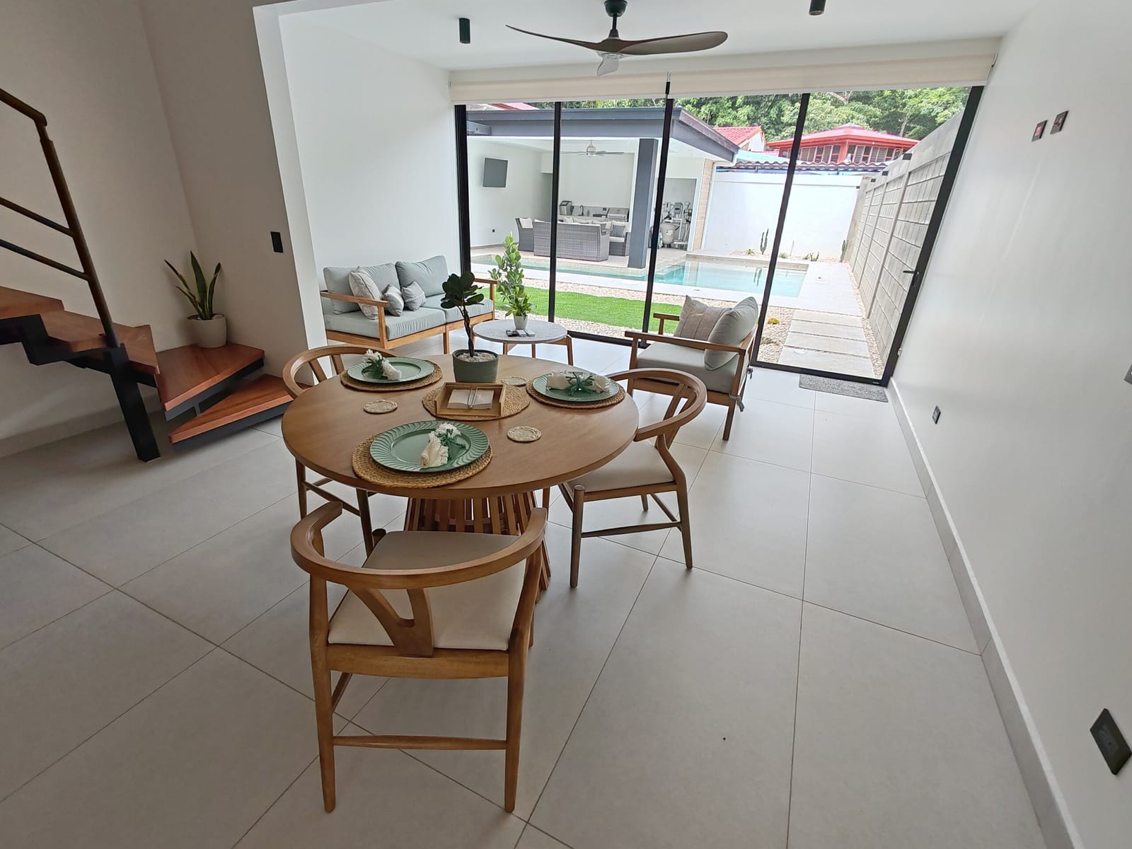 Sofa and dining table with the pool through the glass