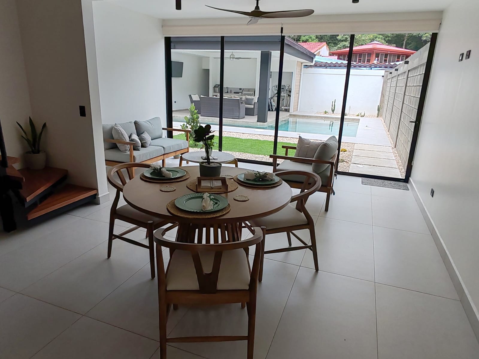 Dining area and sofa opening onto the turf garden