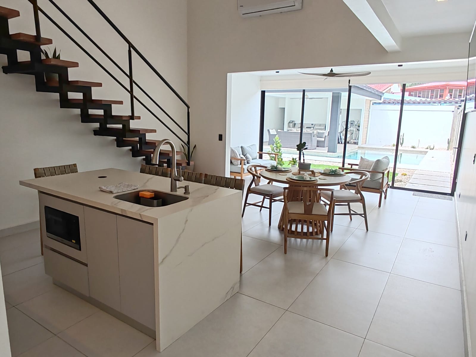 Kitchen island with the dining table and pool beyond