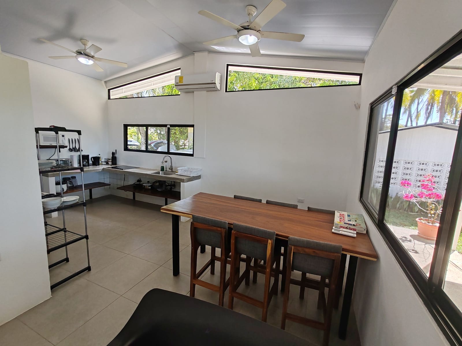 Dining table and kitchen under the open ceiling with fans