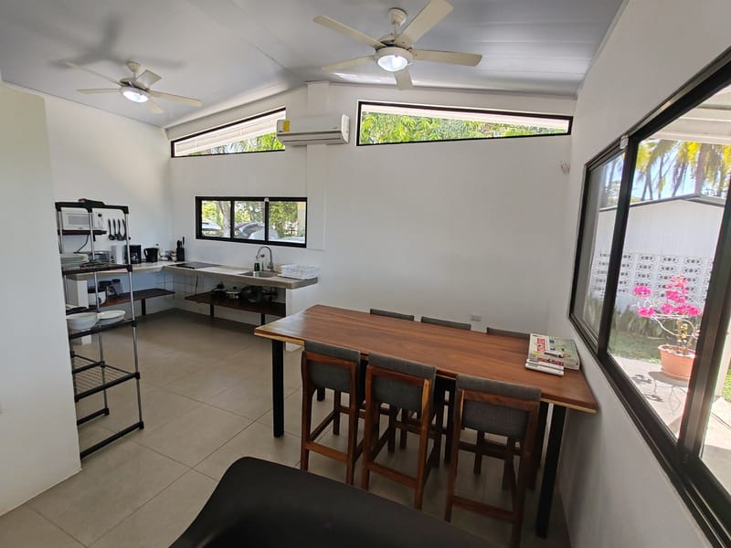 Dining table and kitchen under the open ceiling with fans