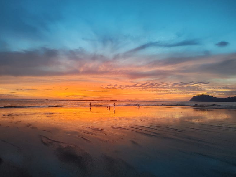 Orange sunset reflected on the wet sand at Playa Sámara