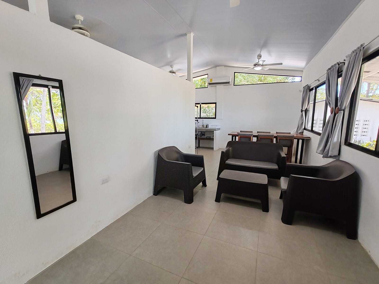Living room with black rattan sofas and a tall mirror