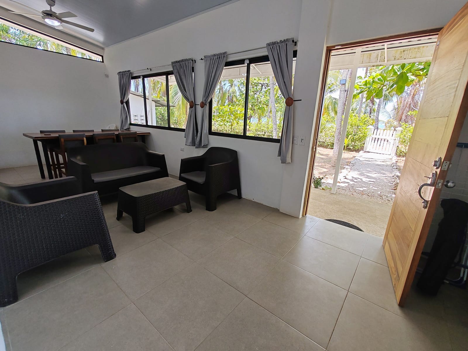 Living room with rattan chairs and the door to the palms