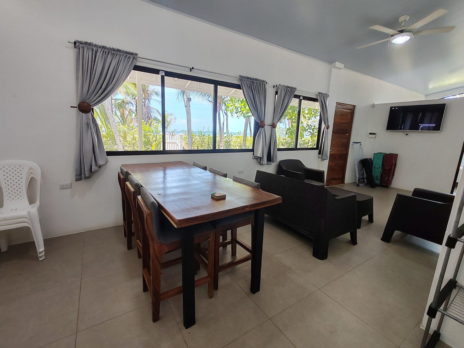 Dining table and rattan chairs with windows to the sea