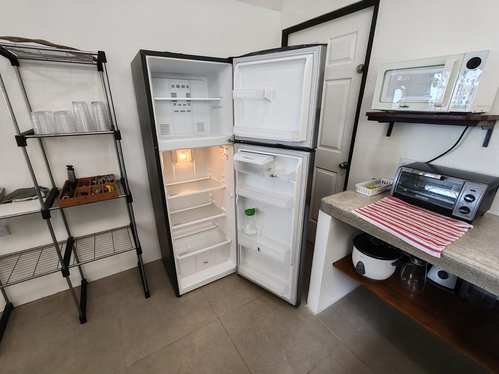 Open refrigerator, microwave and toaster oven in the kitchen