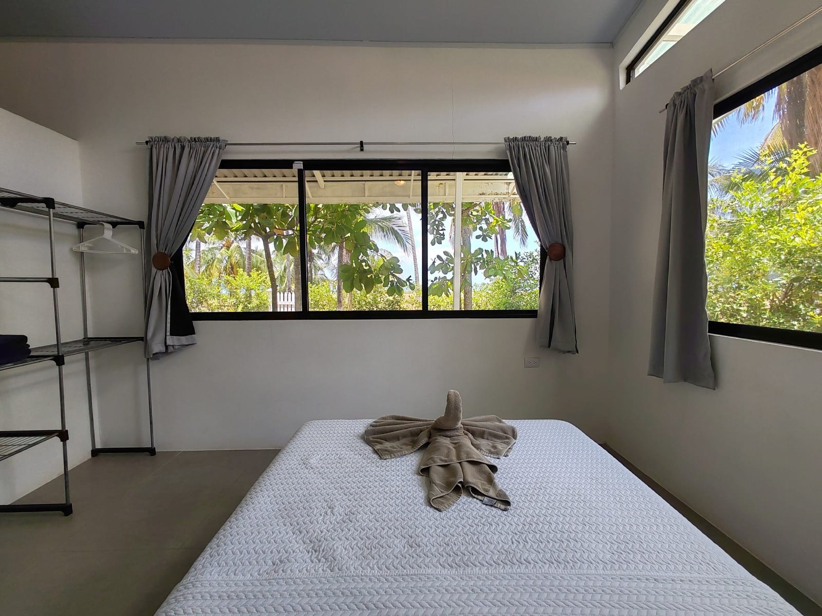 Bed with folded towel by windows to the garden