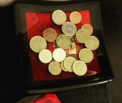 Euro coins on a red and black glass plate